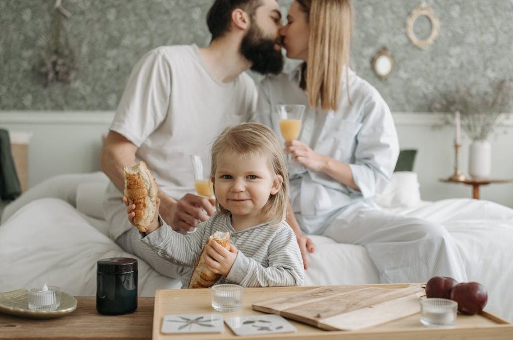 Family enjoying breakfast in bed, expressing love and togetherness.